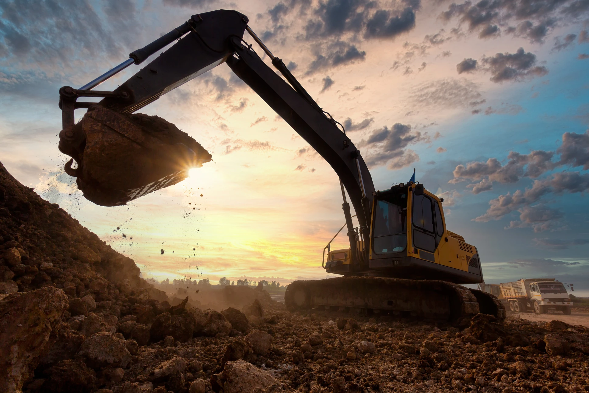 excavatrice à un bac à sable pendant les travaux de terrassement sur le chantier