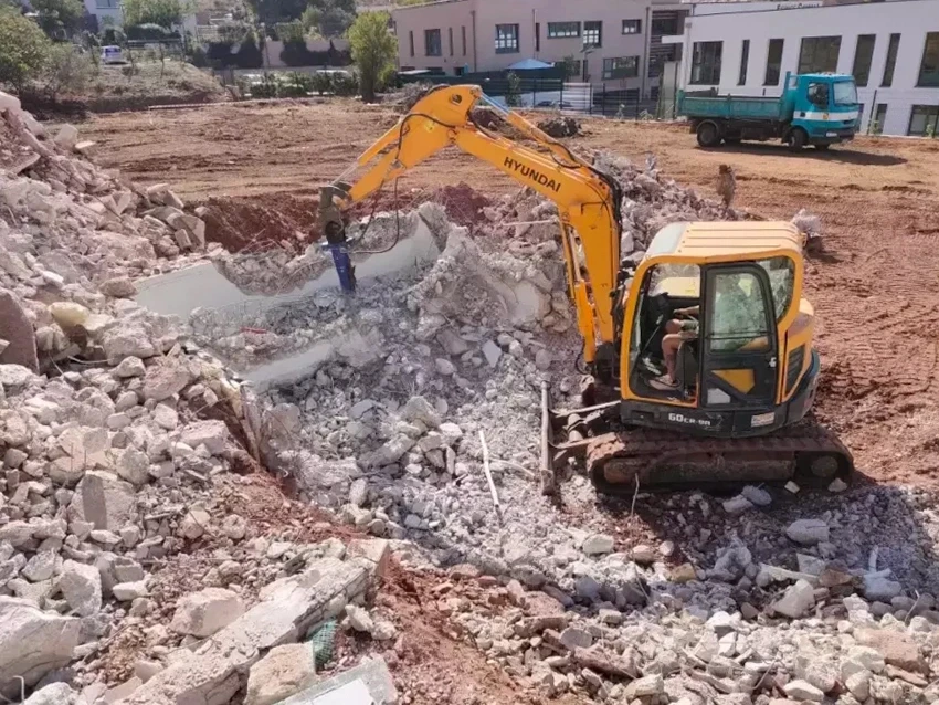 Terrain extérieur avec fosse septique en béton circulaire équipée d'un regard d'accès et d'un conduit de ventilation bleu PVC